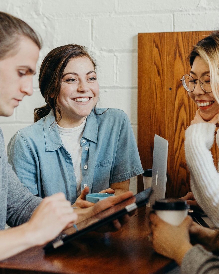 Equipo conversando alrededor de una mesa de trabajo